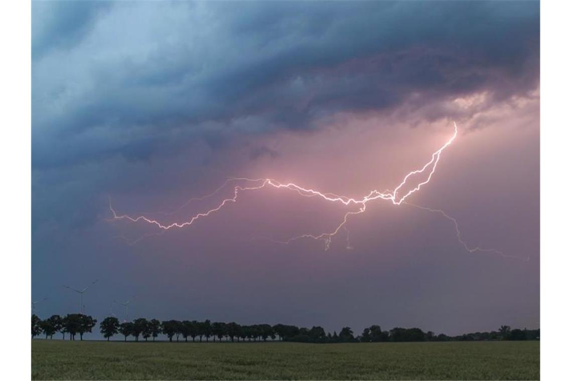 Samstag in Baden-Württemberg bringt Regen und Gewitter Ein Blitz erhellt den Abendhimmel über einem Feld. Foto: Patrick Pleul/dpa-Zentralbild/ZB/Symbolbild