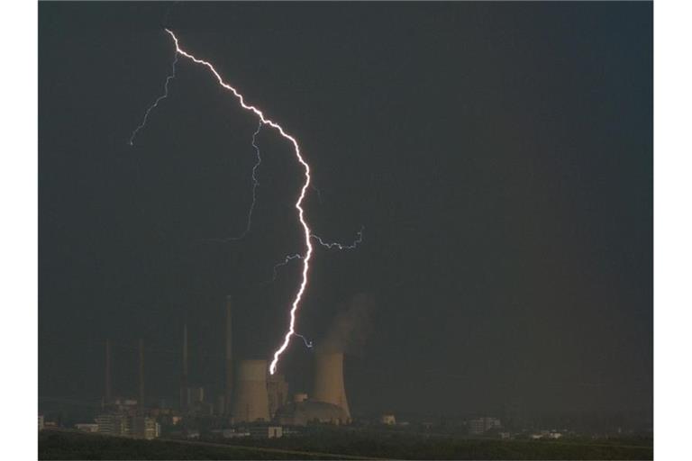 Ein Blitz zuckt hinter dem Kraftwerk Staudinger. Foto: Sebastian Gollnow/dpa