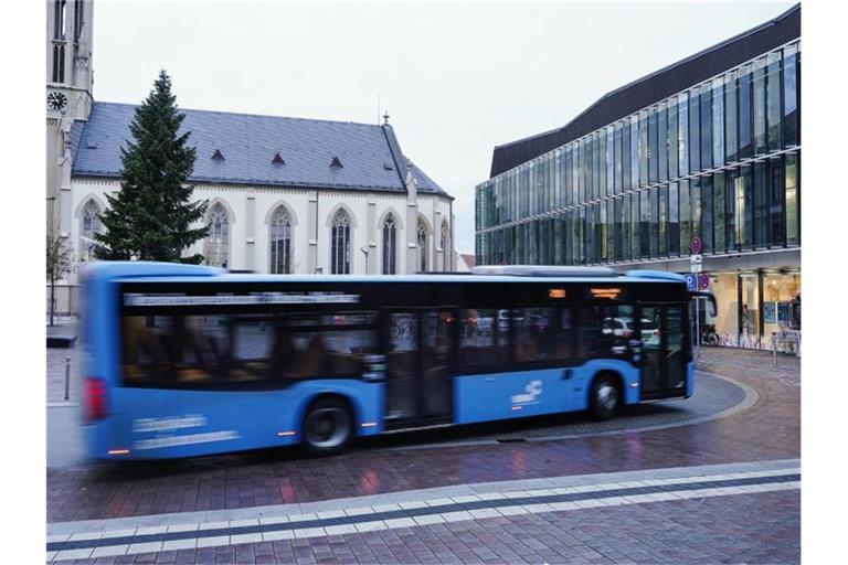 Ein Bus fährt in der Innenstadt an einer Bushaltestelle vorbei. Foto: Uwe Anspach/dpa