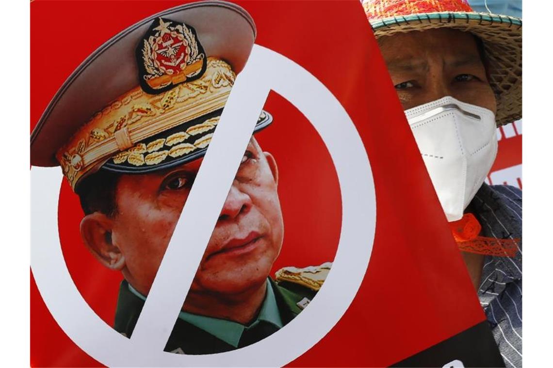Myanmars Militär lässt die Muskeln spielen Ein Demonstrant hält ein Plakat mit einem durchgestrichenen Porträt von General Min Aung Hlaing, dem Anführer der Putschisten. Foto: Uncredited/AP/dpa