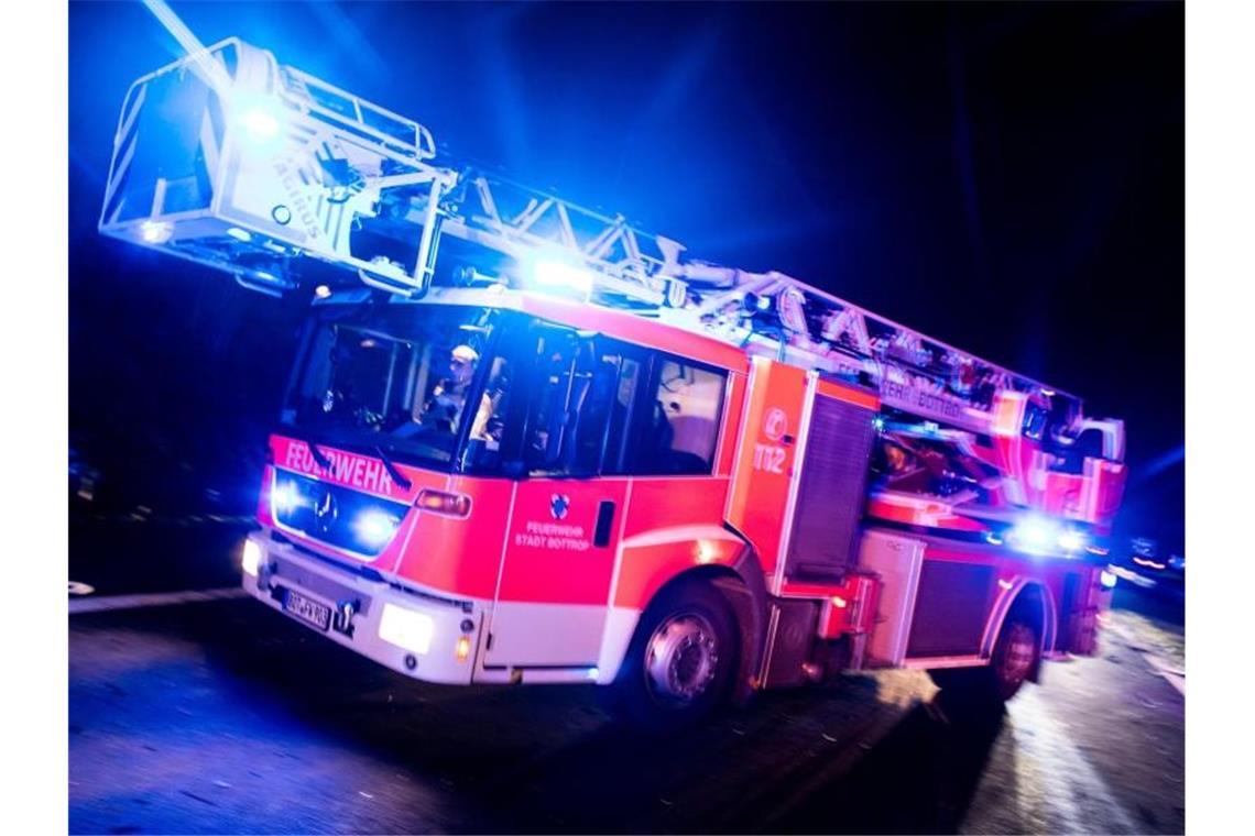 Explosive Post an Firmen: Ermittler setzen Belohnung aus Ein Drehleiterwagen der Feuerwehr fährt mit Blaulicht an einer Unfallstelle vorbei. Foto: Marcel Kusch/dpa/Illustration
