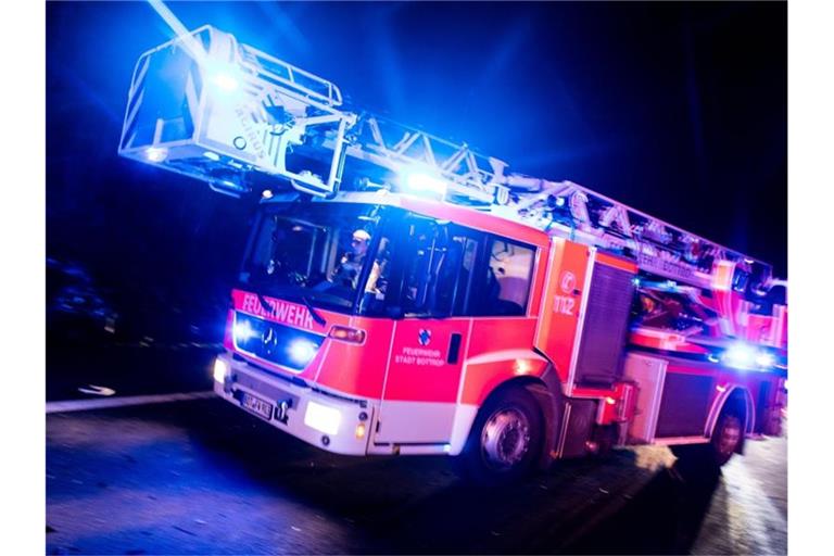 Ein Drehleiterwagen der Feuerwehr ist mit Blaulicht im Einsatz. Foto: Marcel Kusch/dpa/Illustration