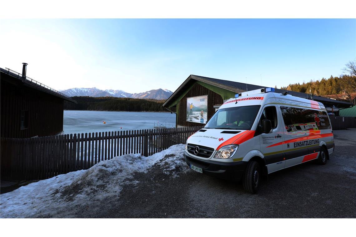 Ein Einsatzfahrzeug des Roten Kreuzes steht am Ufer des Eibsees, nahe der Stelle an der am Nachmittag mehrere Menschen im Eis eingebrochen waren.