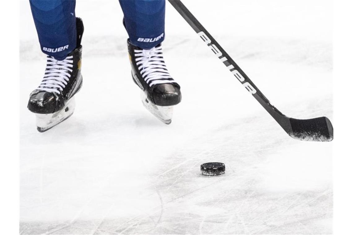 Ein Eishockeyspieler spielt den Puck. Foto: Matthias Balk/dpa/Symbolbild