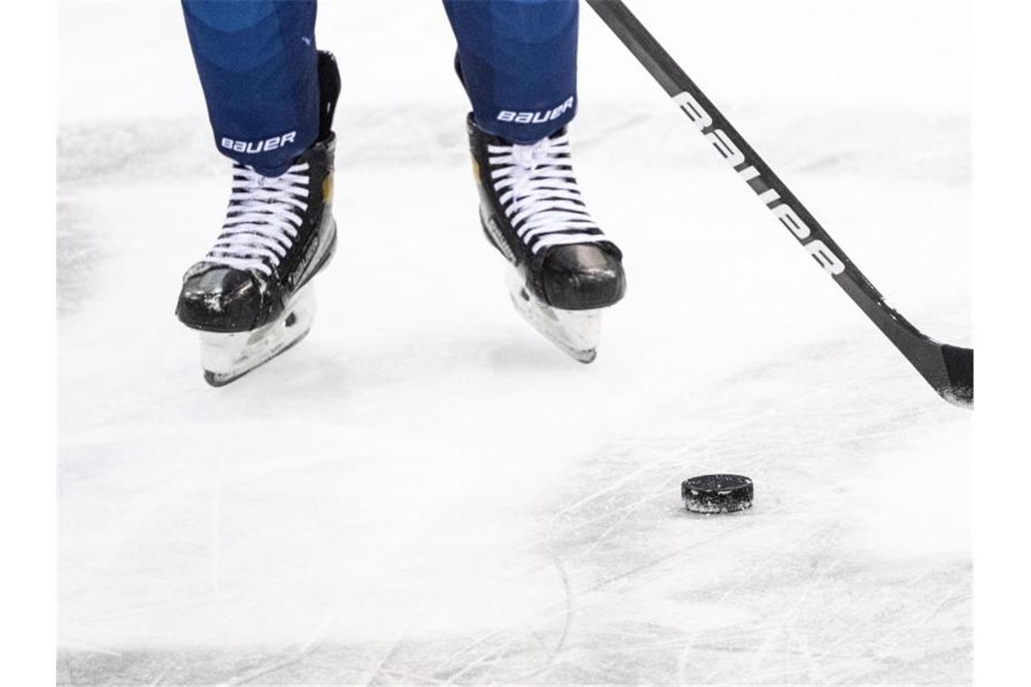 Ein Eishockeyspieler spielt den Puck. Foto: Matthias Balk/dpa/Symbolbild