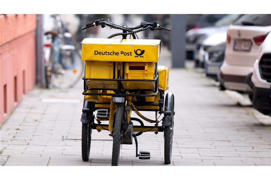 Ein Fahrrad eines Briefträgers steht auf einem Gehweg - auch dieser Briefträger möchte vermutlich gern deutlich besser bezahlt werden.