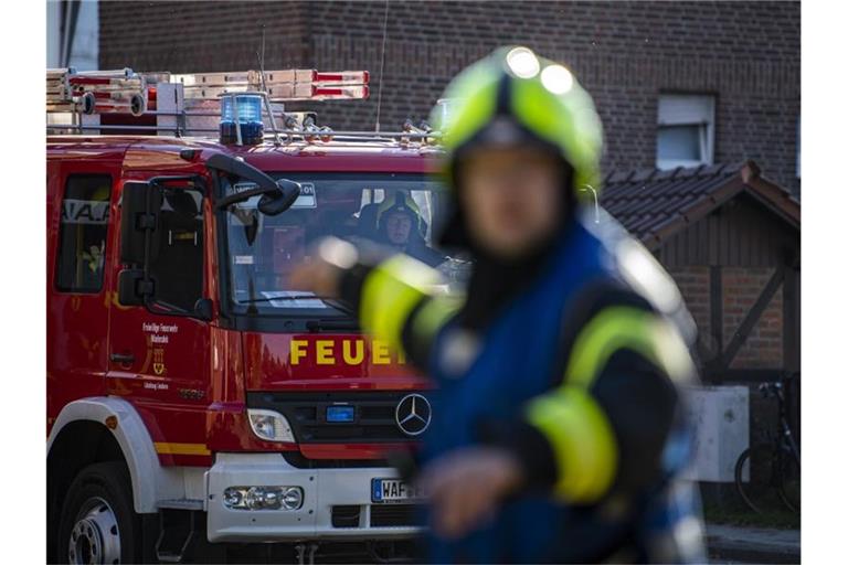 Ein Fahrzeug der Feuerwehr fährt an dem Einsatzort vor und wird vom Wehrführer eingewiesen. Foto: David Inderlied/dpa/Symbolbild