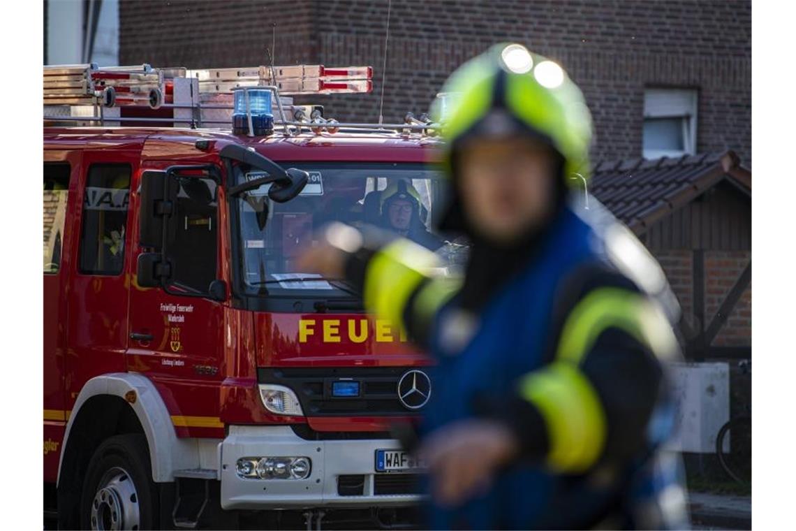 Ein Fahrzeug der Feuerwehr fährt an dem Einsatzort vor und wird vom Wehrführer eingewiesen. Foto: David Inderlied/dpa/Symbolbild