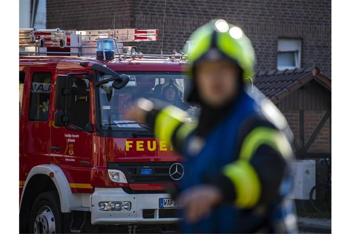 Ein Fahrzeug der Feuerwehr fährt an dem Einsatzort vor und wird vom Wehrführer eingewiesen. Foto: David Inderlied/dpa/Symbolbild