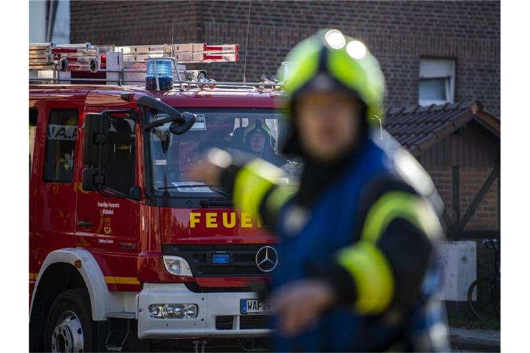 Ein Fahrzeug der Feuerwehr fährt an dem Einsatzort vor und wird vom Wehrführer eingewiesen. Foto: David Inderlied/dpa/Symbolbild