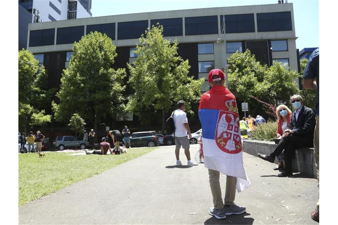 Djokovic-Eltern bei Protest: Ganze Welt wird Wahrheit hören Ein Fan des serbischen Tennisspielers Novak Djokovic steht vor dem Park Hotel in Melbourne, in dem Djokovic untergebracht wird. Foto: Hamish Blair/AP/dpa
