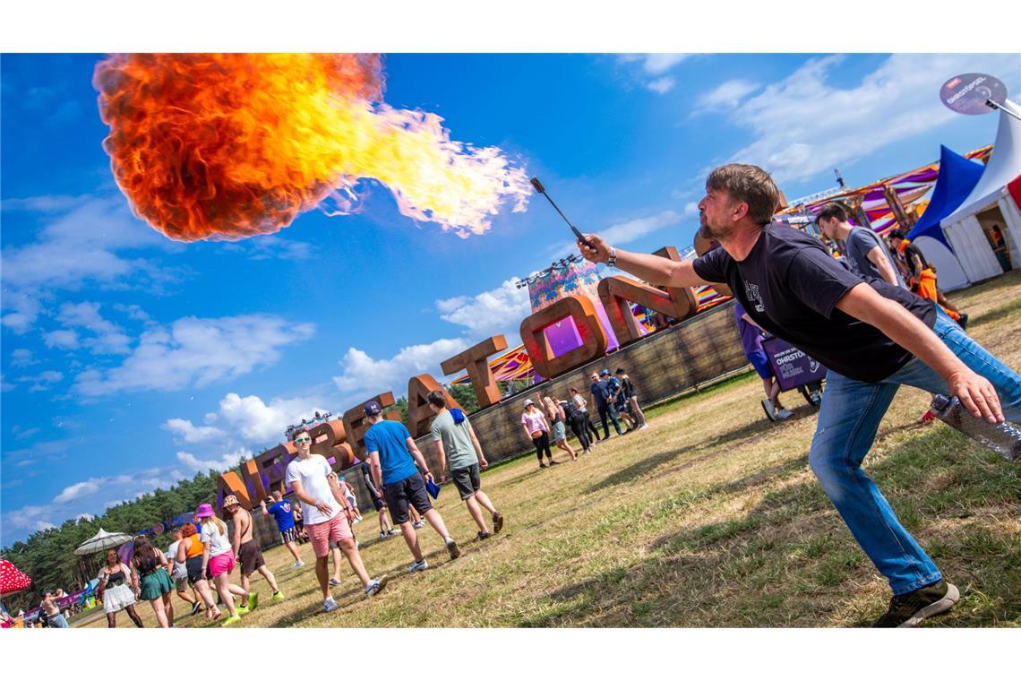 Ein Feuerspucker begrüßt am Eingang die ersten Besucher zum "Airbeat One" Festival.