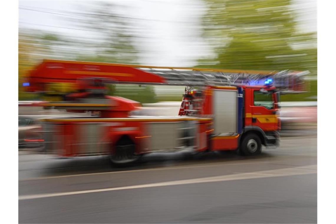 Ein Feuerwehrfahrzeug mit Drehleiter fährt zu einem Einsatz. Foto: Robert Michael/dpa-Zentralbild/ZB/Symbolbild