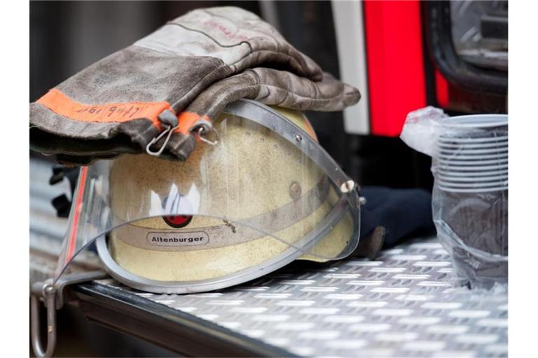 Ein Feuerwehrhelm liegt an einem Einsatzfahrzeug. Foto: picture alliance/dpa/Symbolbild