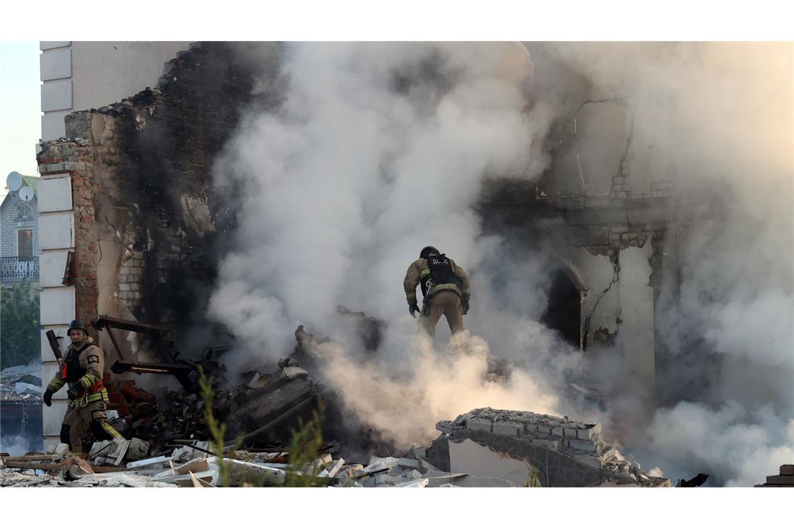 Ein Feuerwehrmann geht durch den Qualm eines brennenden Hauses in Charkiw.