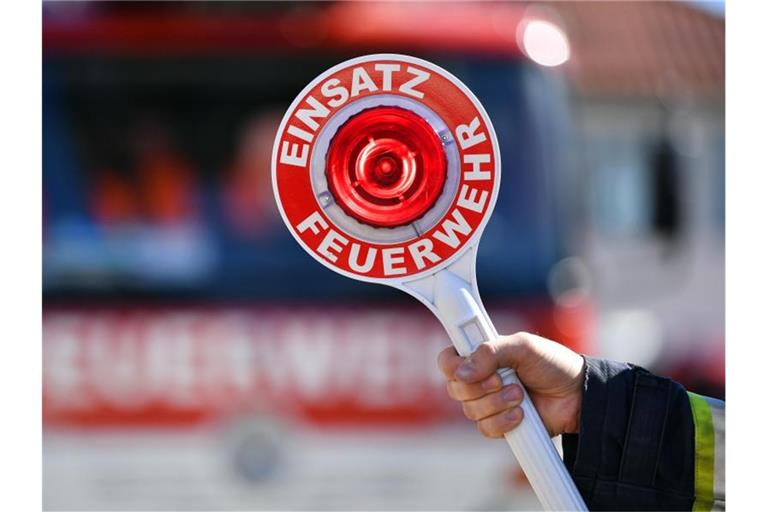 Ein Feuerwehrmann hält eine Winkerkelle mit der Aufschrift „Einsatz Feuerwehr“. Foto: Martin Schutt/dpa-Zentralbild/dpa/Symbolbild