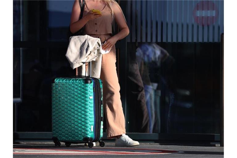 Ein Fluggast steht vor einem Terminal. Foto: Karl-Josef Hildenbrand/dpa/Archivbild