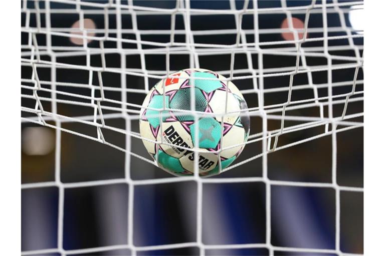 Ein Fußball liegt vor einer Partie im Netz. Foto: Friso Gentsch/dpa/Symbolbild