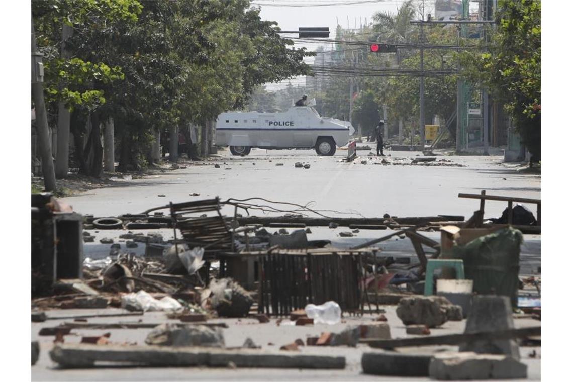 UN: Mindestens 18 Tote bei Protesten in Myanmar Ein gepanzertes Polizeifahrzeug fährt während des Protests gegen den Militärputsch an auf der Straße liegenden Trümmern vorbei. Foto: Uncredited/AP/dpa