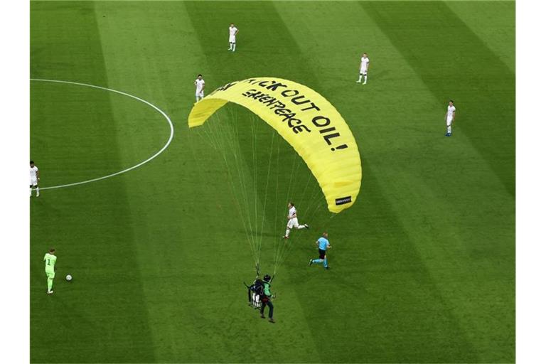 Ein Greenpeace-Aktivist landet auf dem Spielfeld. Foto: Christian Charisius/dpa/Archivbild