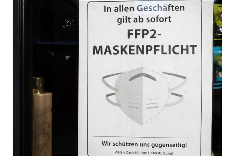 Ein Hinweisschild zur FFP2 Maskenpflicht hängt am Eingang einer Apotheke. Foto: Bernd Weißbrod/dpa/Symbolbild