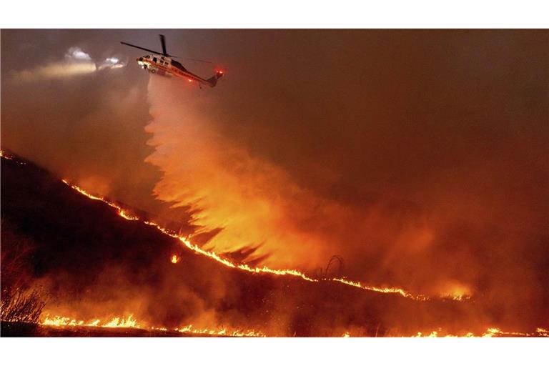 Ein Hubschrauber wirft Wasser auf das Kenneth-Feuer in den West Hills von Los Angeles.