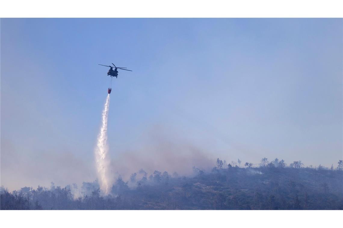 Ein Hubschrauber wirft Wasser auf einen Waldbrand auf dem Berg Parnitha nördlich von Athen ab. Unter Einsatz von 15 Löschflugzeugen und Hubschraubern, hunderter Feuerwehrleute und Freiwilligen, konnte der Brand gelöscht werden. Die Brandgefahr bleibt jedoch weiterhin sehr hoch.