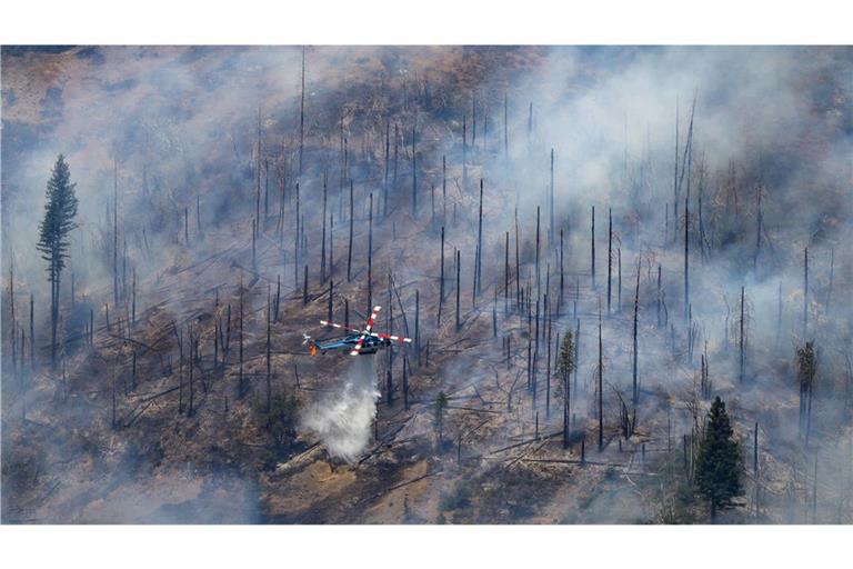 Ein Hubschrauber wirft Wasser zum Löschen auf das Park Fire in der Nähe von Butte Meadows, Kalifornien.