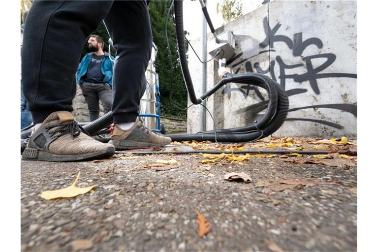 Ein Jugendlicher entfernt mit Hilfe eines Betreuers (hinten) ein Graffiti von der Wand. Foto: Bernd Weißbrod/dpa/Archivbild