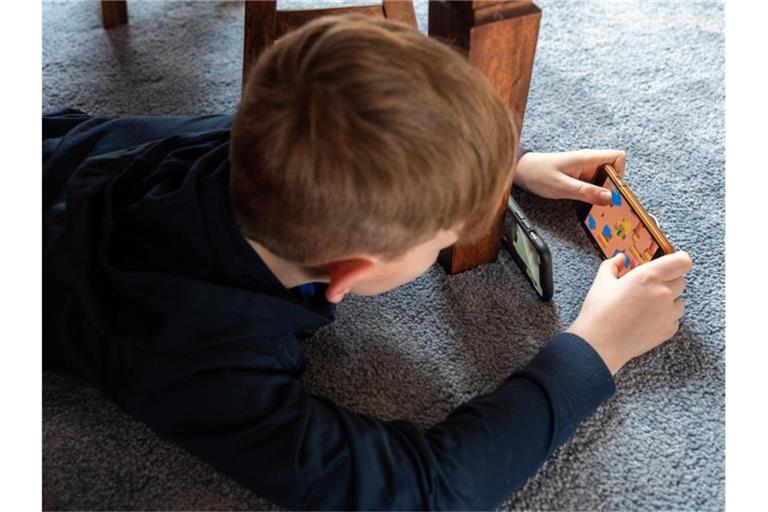 Ein Junge spielt ein Videospiel auf seinem Smartphone. Foto: Robert Michael/dpa-Zentralbild/dpa/Archivbild