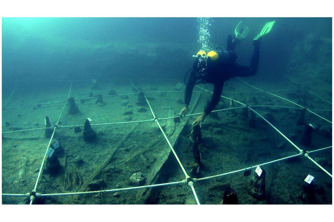 Ein Kanu wird Boden des Braccianosees ausgegraben. Die abgenutzten Überreste der mehr als 7000 Jahre alten Kanus lassen erahnen, wie ausgeprägt das Wissen über die Seefahrt bereits in der Jungsteinzeit war.