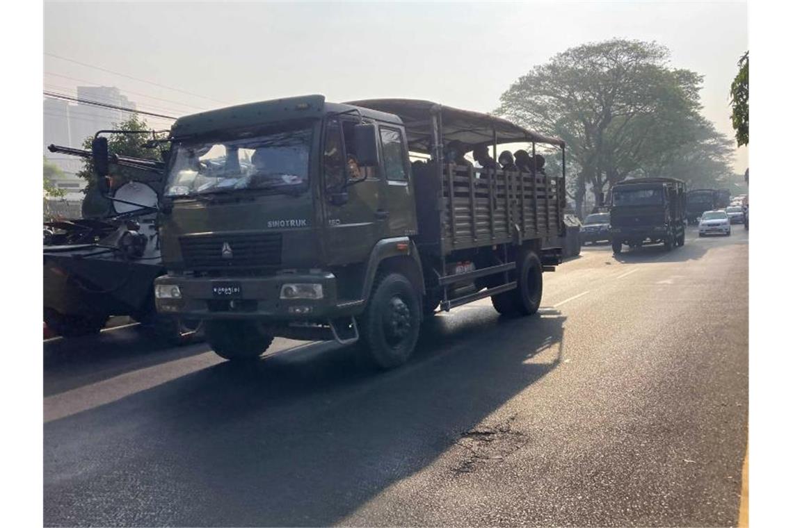 Myanmars Militär lässt die Muskeln spielen Ein Konvoi von Militärlastwagen mit Soldaten fährt in Rangun an gepanzerten Militärfahrzeugen vorbei. Das Militär zeigt in mehreren Städten des Landes starke Präsenz. Foto: Uncredited/AP/dpa