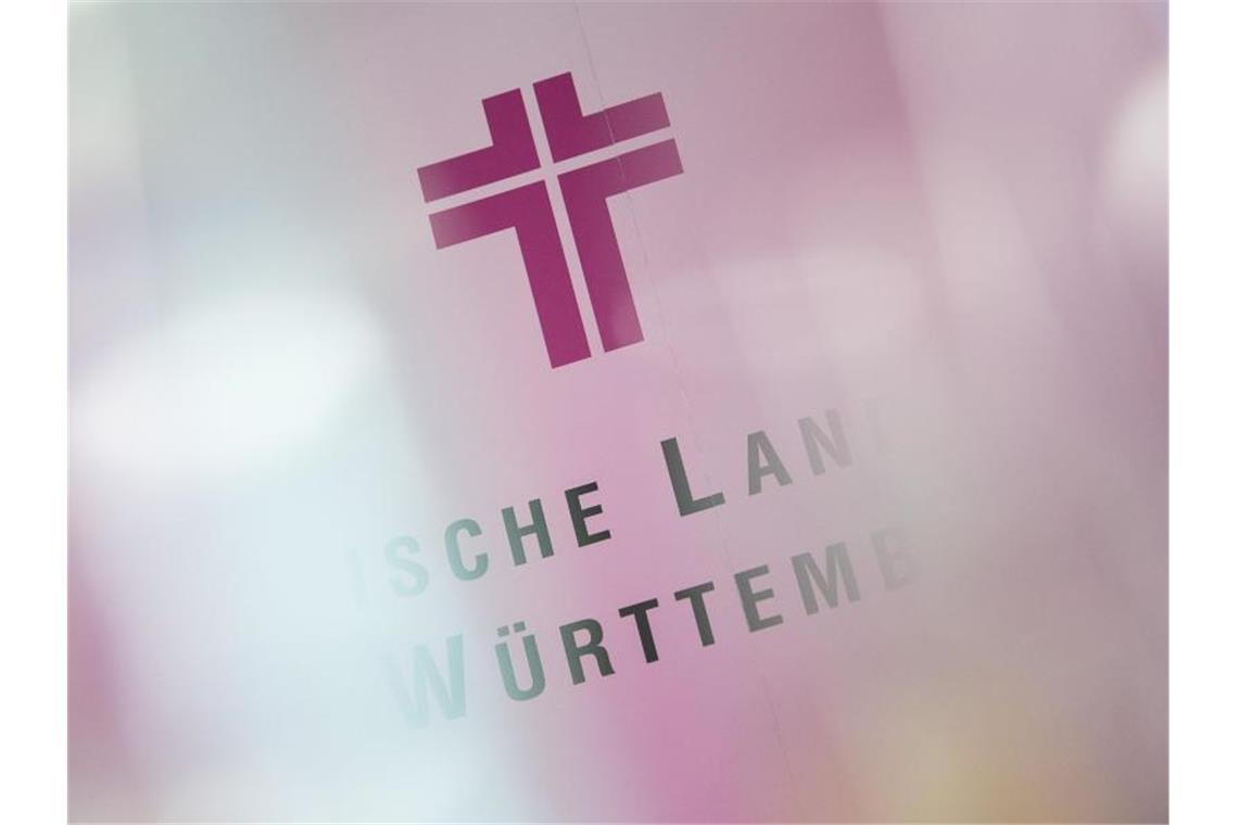Nach der Wahl ist vor der Wahl: Kirche stimmt neu ab Ein Kreuz im Logo der evangelischen Landeskirche in Württemberg steht auf einer Fotowand. Foto: Sebastian Gollnow/dpa/Symbolbild