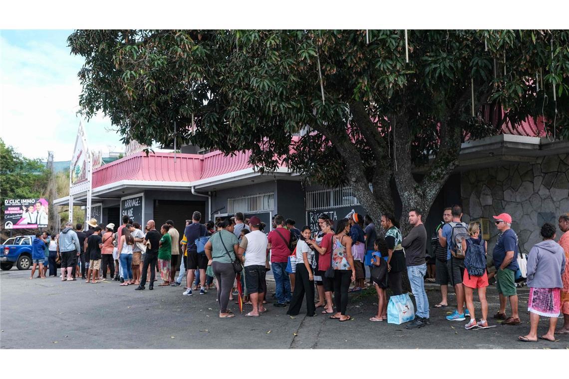 Ein lange Schlange vor einem 
Gemischtwarenladen in Nouméa.