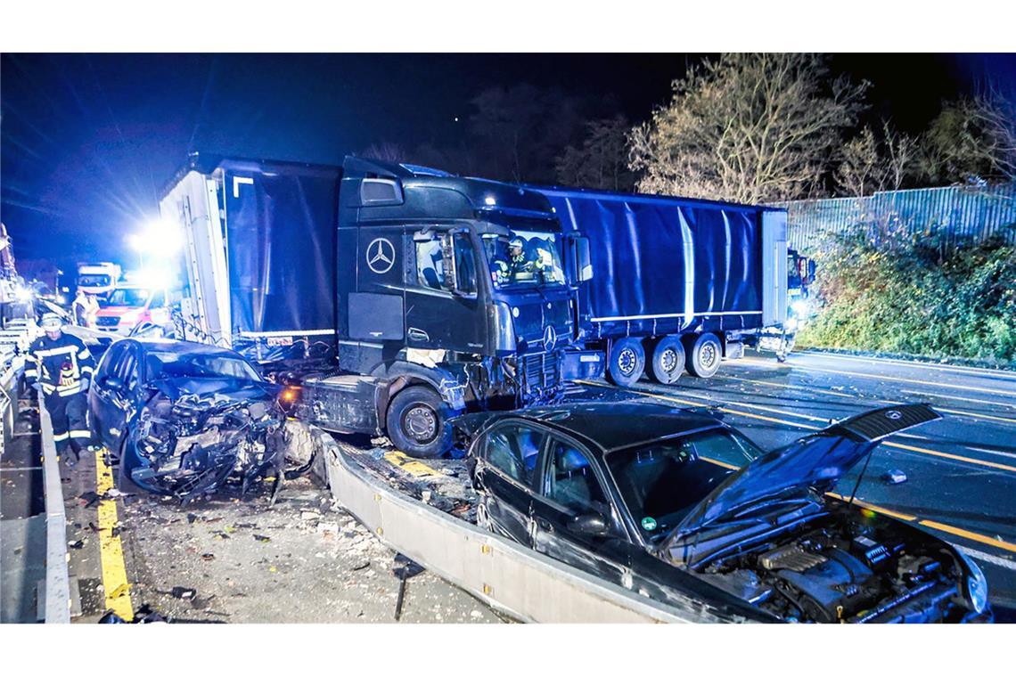 Ein Lastwagen steht nach einer Chaosfahrt auf der A1 bei Hagen an der Unfallstelle neben beschädigten Autos.