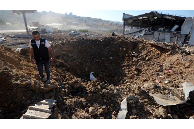 Ein libanesischer Polizist steht in der Nähe eines Kraters nach einem israelischen Luftangriff auf einen Hangar im Südlibanon.