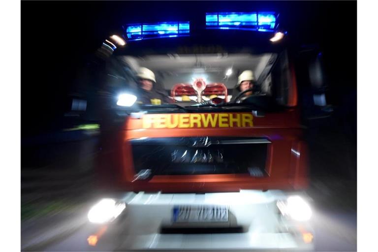 Ein Löschfahrzeug fährt mit Blaulicht über eine Straße. Foto: Carsten Rehder/dpa/Symbolbild