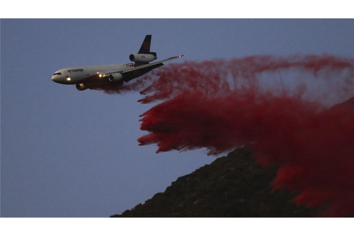 Ein Löschflugzeug wirft bei der Bekämpfung des Eaton-Brandes in Altadena Löschmittel ab.