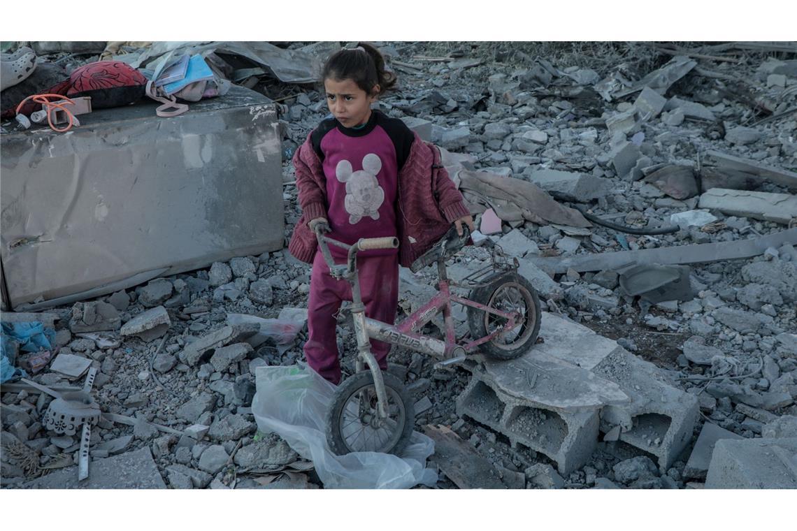 Ein Mädchen rettet ihr Fahrrad nach israelischem Bombardement im Flüchtlingslager Al-Maghazi im zentralen Gazastreifen.