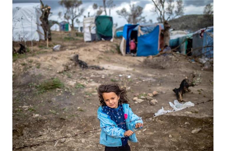 Ein Mädchen steht am Stacheldrahtzaun in einem Zeltlager nahe des Camps für Migranten in Moria. Foto: Angelos Tzortzinis/DPA/dpa/Archivbild