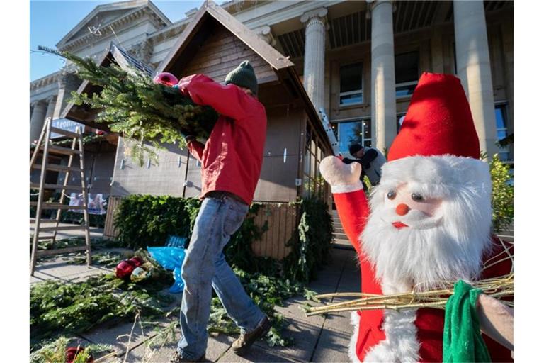 Ein Mann baut einen Stand auf dem Stuttgarter Weihnachtsmarkt ab. Foto: Bernd Weißbrod/dpa/Archivbild