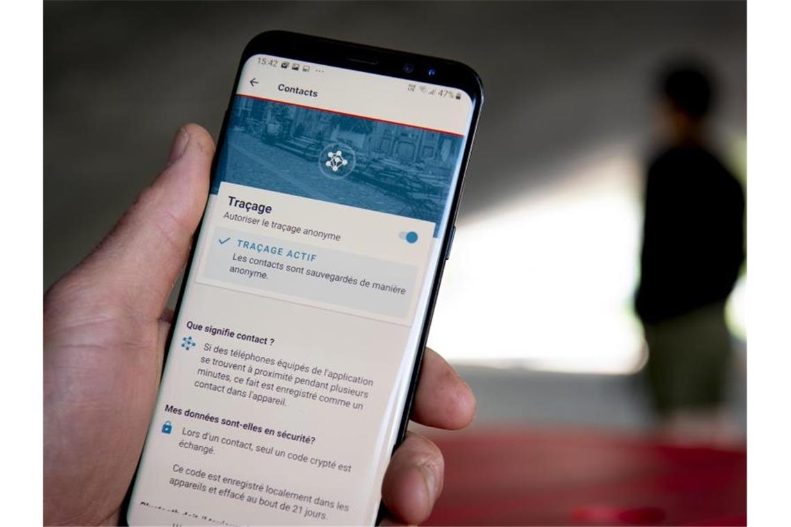 Deutsche und Schweizer Corona-Warn-App verknüpft Ein Mann benutzt die Tracing-App SwissCovid auf seinem Smartphone. Foto: Laurent Gillieron/KEYSTONE/dpa/Archivbild