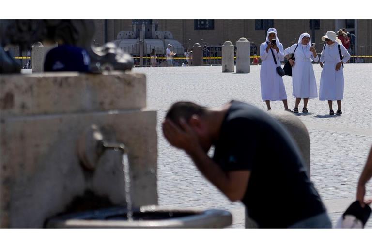 Ein Mann erfrischt sich an einem Brunnen auf dem Petersplatz, während die Temperaturen bis zu 38 Grad Celsius im Vatikan erreichen.