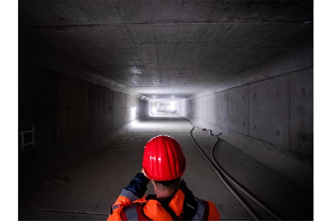 Ein Mann fotografiert mit seinem Smartphone den neuen Abwasserkanal „Düker Nesenbach“. Foto: Christoph Schmidt/dpa