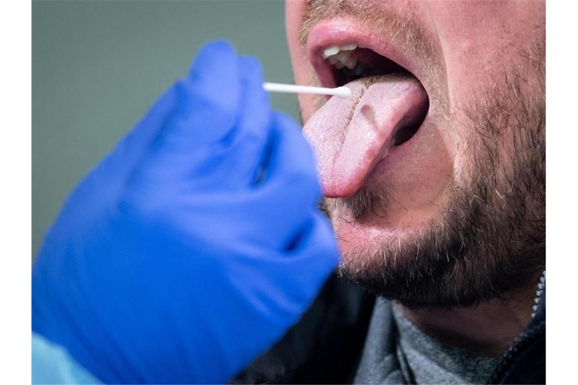 Wenige Südwest-Betriebe testen ihre Mitarbeiter schon selbst Ein Mann führt einen Rachenabstrich bei einem Mann durch. Foto: Matthias Balk/dpa/Archivbild