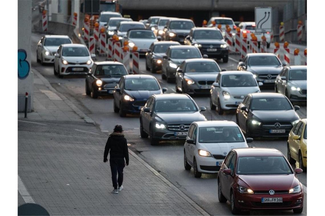 Ein Mann geht in der Innenstadt an Autos, die im Stau stehen, vorbei. Foto: Marijan Murat/dpa/Archivbild