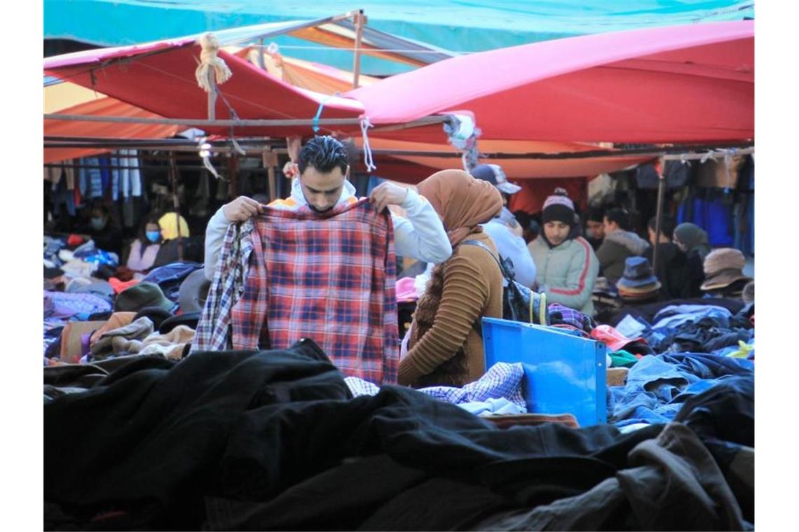 Kleidung: Afrika wird zur „Müllkippe des Westens“ Ein Mann hält sich auf einem Altkleidermarkt ein Hemd an. Foto: Cindy Riechau/dpa