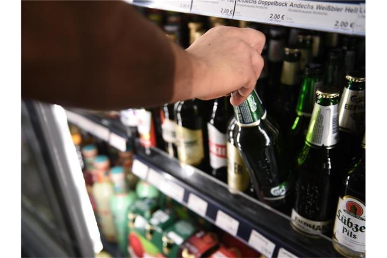 Ein Mann holt eine Flasche Bier aus einem Kühlschrank in einem Spätkauf in Berlin-Mitte. Foto: Sven Braun/dpa