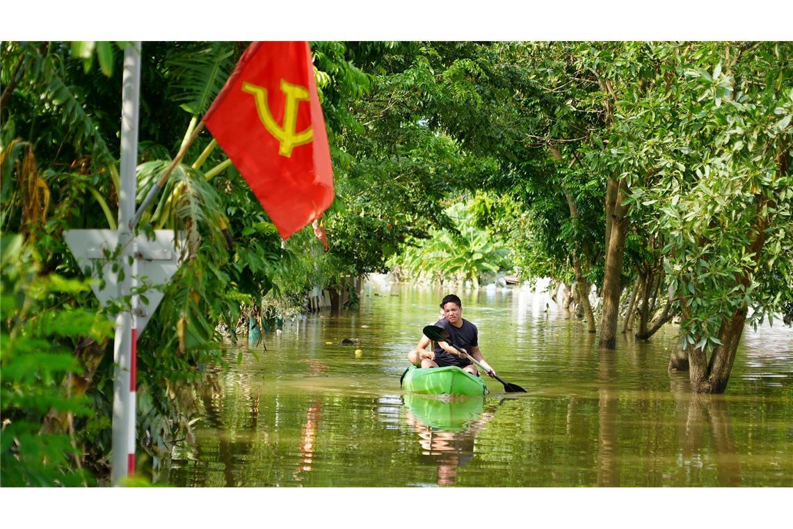 Ein Mann paddelt in der Nähe von Hanoi durch das Hochwasser.