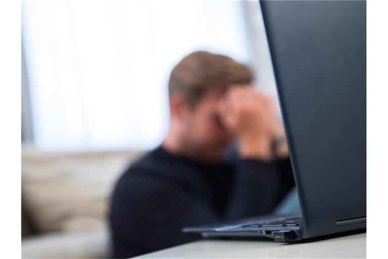 Ein Mann sitzt vor einem Laptop und fasst sich an den Kopf. Foto: Christin Klose/dpa-tmn/dpa